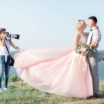 wedding photographer takes pictures of bride and groom in nature. wedding couple on photo shoot. photographer in action